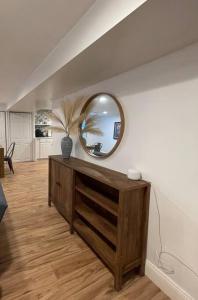 a living room with a mirror and a wooden dresser at Upscale, Brand New, Full Kitchen, 2-Bedroom Apt in Falls Church