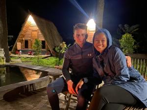 a man and a woman sitting on a bench at night at Triangle House and hot spring in Kintamani
