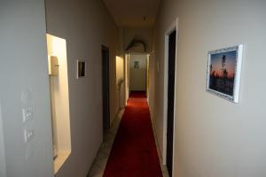 a hallway with a red carpet and a hallway with white walls at Ιlias rooms in Patra