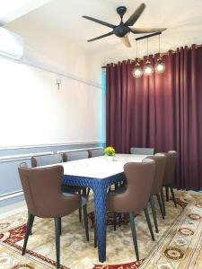 a dining room with a table and chairs and a ceiling fan at HOMESTAY EPOH Meru Raya in Ipoh