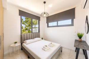 1 dormitorio con cama y ventana en Alasia Villas, en Paralimni