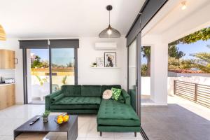 a living room with a green couch and a table at Alasia Villas in Paralimni