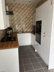 a kitchen with white cabinets and a tile floor at City Centre 1 Bed Sleeps 4 H5 in Hull +10 photos