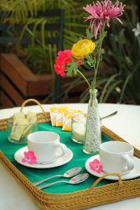 einen Tisch mit zwei Tassen und eine Vase mit Blumen in der Unterkunft Casa Madonna in Guadalajara