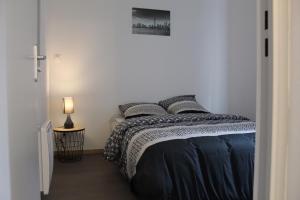 a bedroom with a bed and a picture on the wall at LES COTTAGES DU PRYTANEE in La Flèche