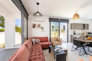 a living room with a couch and a table at Alasia Villas in Paralimni