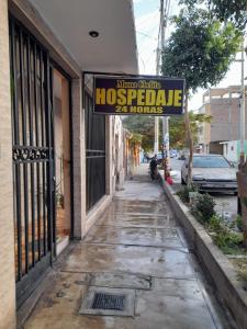 une rue avec un panneau indiquant les heures de parasite de la maison dans l'établissement Mama Chelita, à Nazca