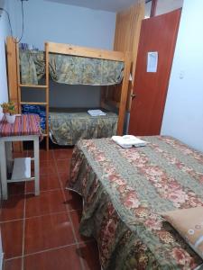 a room with two beds and a bunk bed at Mama Chelita in Nazca