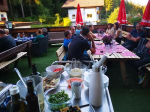 a group of people sitting at a table with food at Pension Concordia aktuel in Ramsau am Dachstein