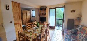 a dining room with a table and chairs and a couch at Les Crêtes studio divisible by Mountain Collection Immobilier in Le Monêtier-les-Bains +7 photos