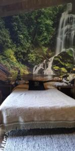 ein Schlafzimmer mit einem Wasserfall-Wandbild in der Unterkunft Alcázar Milmanda in Milmanda