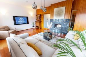 un soggiorno con divano bianco e camino di Luxury Apartment Villa Černigoj a Maribor