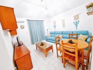 a living room with a table and a blue couch at Dunas y Luz in Rota