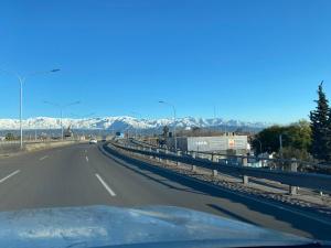 una autopista con montañas cubiertas de nieve en la distancia en Departamento en el corazón de Mendoza en Mendoza