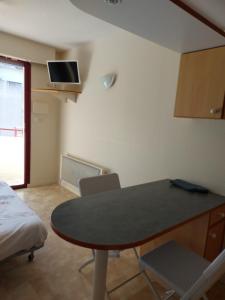 a room with a table and chairs and a bed at Le Cosy des Minimes in La Rochelle