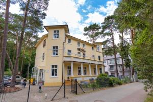 żółty budynek z napisem "hotel" w obiekcie Bethel w mieście Ustronie Morskie