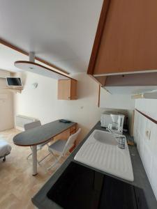 a small kitchen with a sink and a table at Le Cosy des Minimes in La Rochelle