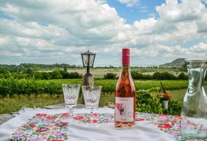 a bottle of wine sitting on a table with glasses at Máli Pince in Aszófő