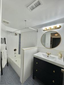 y baño con lavabo, bañera y espejo. en Upscale, Brand New, Full Kitchen, 2-Bedroom Apt, en Falls Church