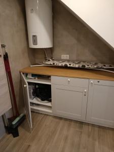 uma cozinha com armários brancos e uma bancada em Liūto apartamentai em Juodkrantė