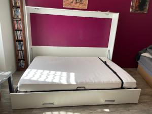 a bed with a white frame in a room at Le studio in Montclar