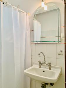 bagno con lavandino e specchio di Costas Rooms a Città di Egina