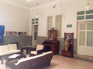 a living room with a couch and a piano at Hotel de los ba&ntilde;os in Pachuca de Soto