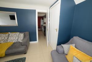 uma sala de estar com um sofá e uma parede azul em Notting Hill West in the heart of Westport Town em Westport