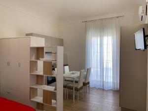 a kitchen and dining room with a table and a room at Casa Katrin & Casa Brigida in Castellammare del Golfo