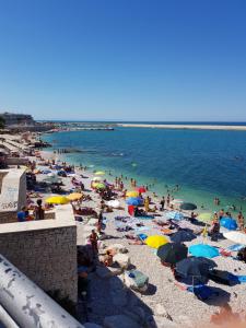a crowd of people on a beach with umbrellas at B&b Le Monache in Bisceglie