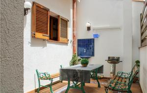 een patio met een tafel en stoelen en een grill bij Beautiful Apartment In Tossa De Mar With 2 Bedrooms And Wifi in Tossa de Mar