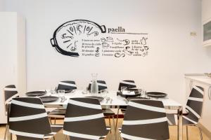 Una mesa con sillas y un reloj en la pared. en Sol - 5 Tirso de Molina - ALQUILER CORTA ESTANCIA, en Madrid