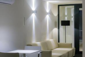 - un salon avec un canapé et des lumières sur le mur dans l'établissement IROCO HOSTAL, à Cala d´Or