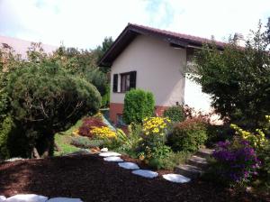 a garden in front of a house with flowers at Le lotus zen 