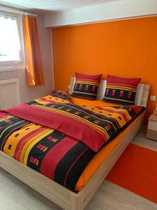 um quarto com uma cama com uma parede laranja em Le lotus zen 