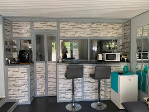 uma cozinha com uma parede de tijolos com um balcão e bancos em Le lotus zen 