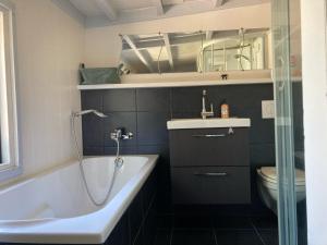 ein Badezimmer mit einer Badewanne, einem Waschbecken und einem WC in der Unterkunft De Weide Blick in Biggekerke