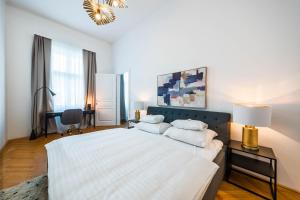 een witte slaapkamer met een groot bed met 2 kussens bij Smile Apartments am Stadtpark in Krems an der Donau