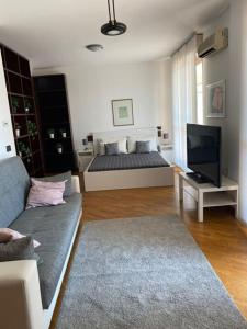 uma sala de estar com uma cama e um sofá em BedandBreakfast Eni Torri Lombarde San Donato BBqueen em San Donato Milanese