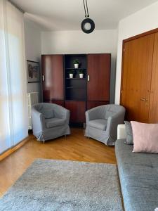 uma sala de estar com duas cadeiras e um sofá em BedandBreakfast Eni Torri Lombarde San Donato BBqueen em San Donato Milanese