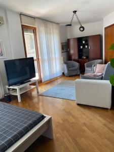 uma sala de estar com uma televisão de ecrã plano e um sofá em BedandBreakfast Eni Torri Lombarde San Donato BBqueen em San Donato Milanese