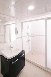a white bathroom with a sink and a shower at Kiwi Express Hotel - Kaohsiung Station in Kaohsiung