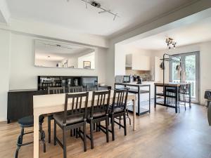 a kitchen and dining room with a table and chairs at Superbe appartement entièrement rénové au pied des montagnes avec parking inclus in Bagnères-de-Bigorre