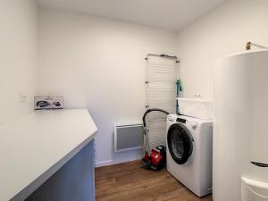 a laundry room with a washing machine and a counter at Superbe appartement entièrement rénové au pied des montagnes avec parking inclus in Bagnères-de-Bigorre