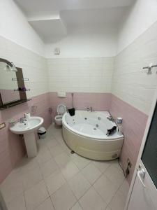 a bathroom with a tub and a sink and a toilet at Grand Hotel Gjyshi in Qerrexhias