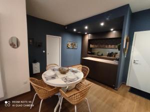 a dining room with a table and chairs and a kitchen at L'EDEN DU LYS in Cauterets