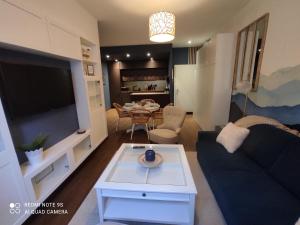 a living room with a couch and a tv and a table at L'EDEN DU LYS in Cauterets