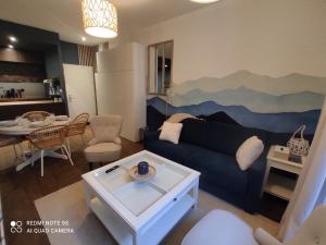 a living room with a blue couch and a table at L'EDEN DU LYS in Cauterets