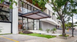 una vista exterior de un edificio blanco con un árbol en Elegant apartment well located in the hotel zone of Cancun, en Cancún