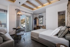 1 dormitorio con cama, mesa y sofá en Vivere Luxury Suites en Pera Gyalos